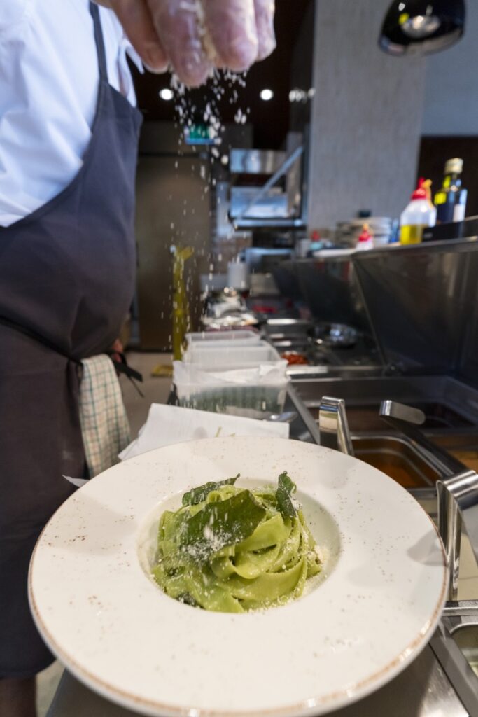 Chef plating fresh green ribbon pasta at Bianco Italian Restaurant Caloundra