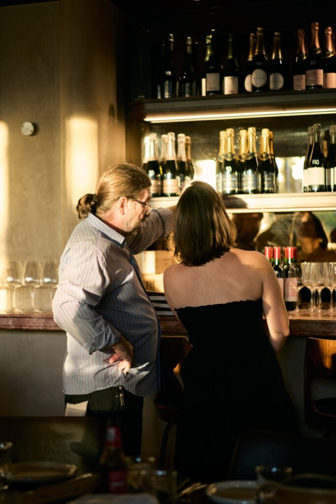 Man and woman standing at the bar reviewing wine selection at Bianco Italian restaurant in Caloundra during opening night