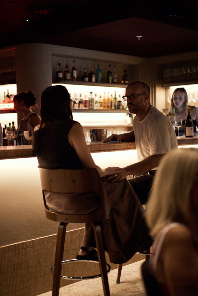 Couple seated at the bar inside Bianco Italian restaurant in Caloundra enjoying drinks in a warm, intimate setting